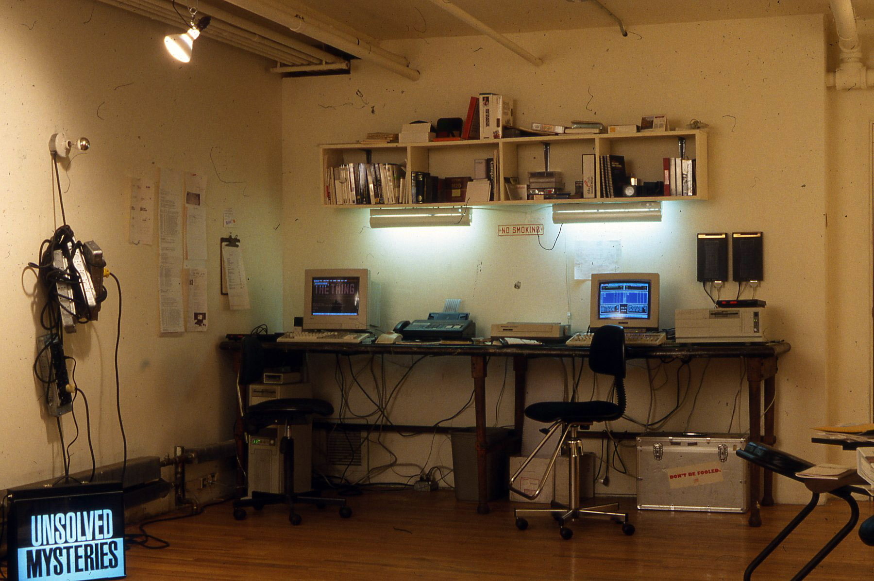 an open office area featuring a desk and two computers from the 1990s