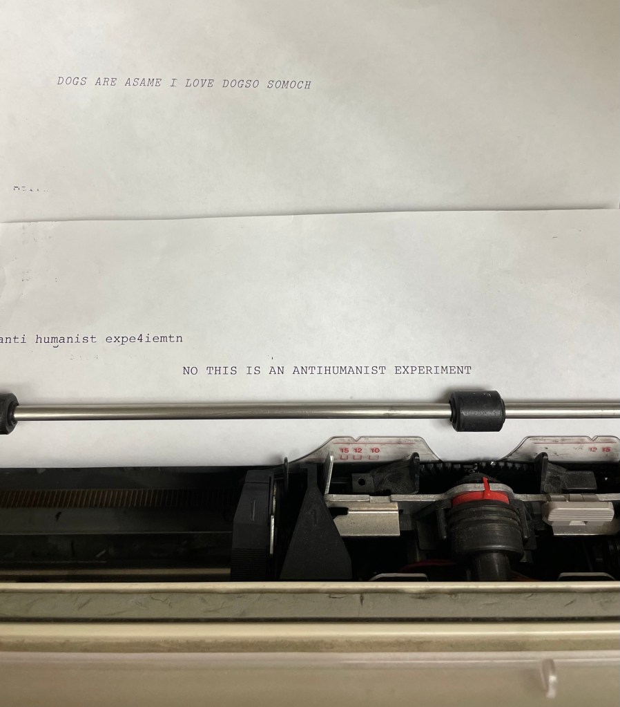 image of sheet of paper in typewriter; text reads "NO THIS IS AN ANTIHUMANIST EXPERIMENT"